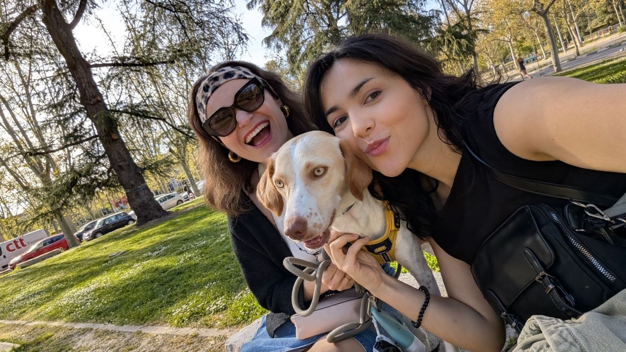 Chiara y Natalia con un perro blanco y canela en un parque de Madrid